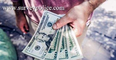 Man holding cash earned from taking surveys